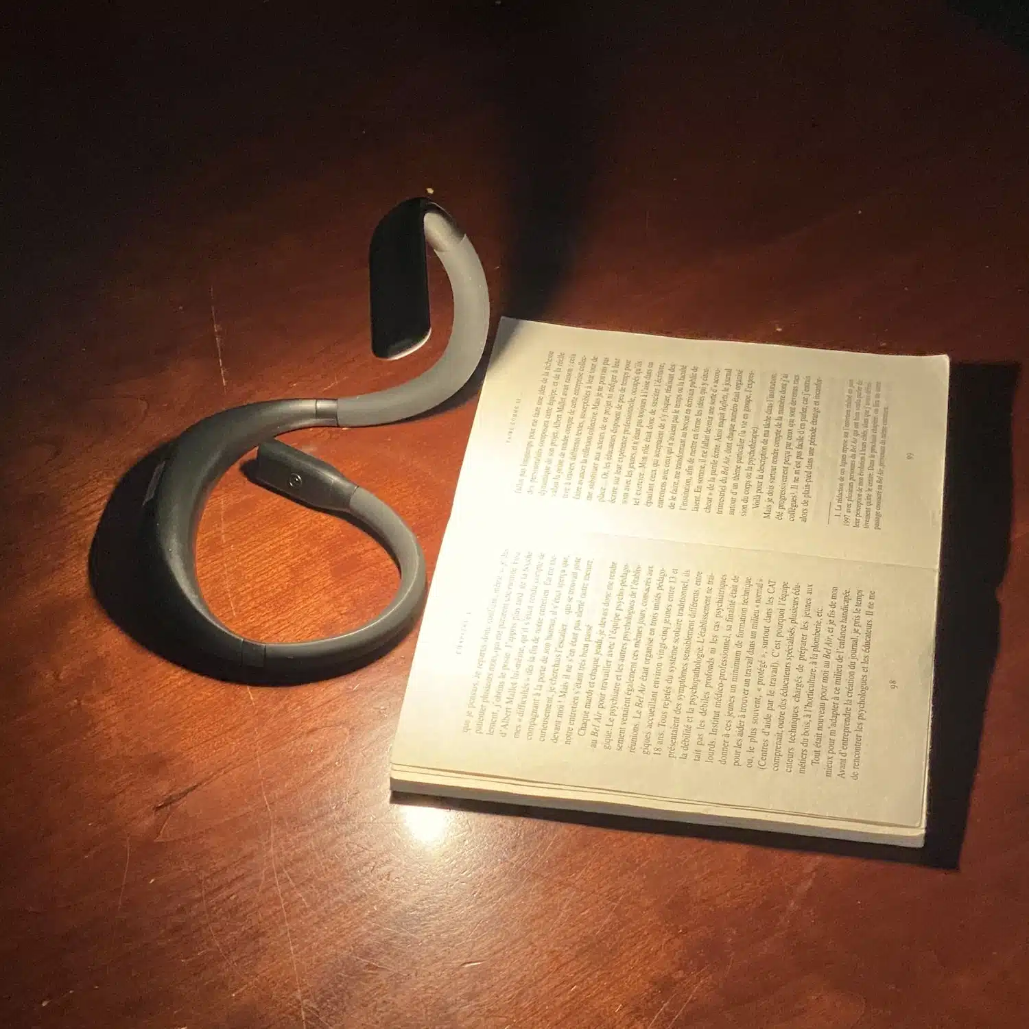 Lampe de lecture AINA, basse vision, posée sur une table éclairant un livre